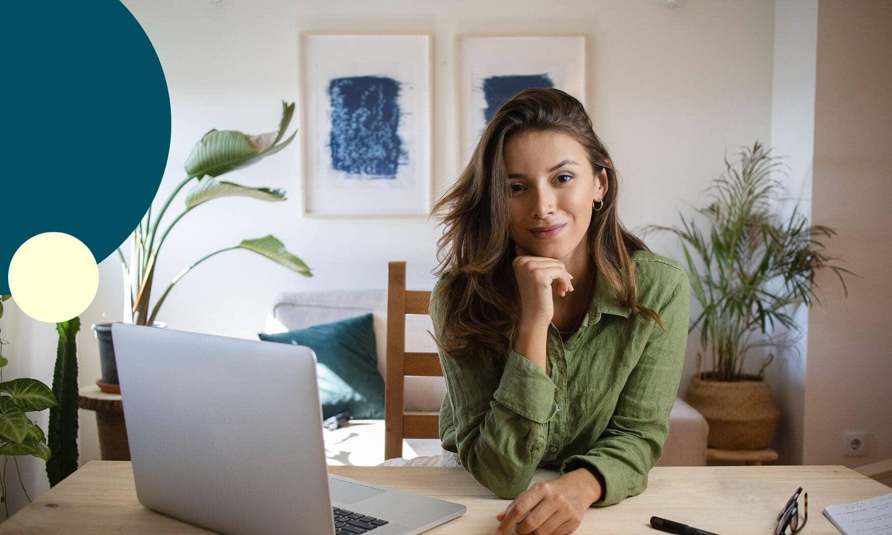 Femme installée à son bureau avec son ordinateur et regardent l'objectif d'un air confiant et satisfait